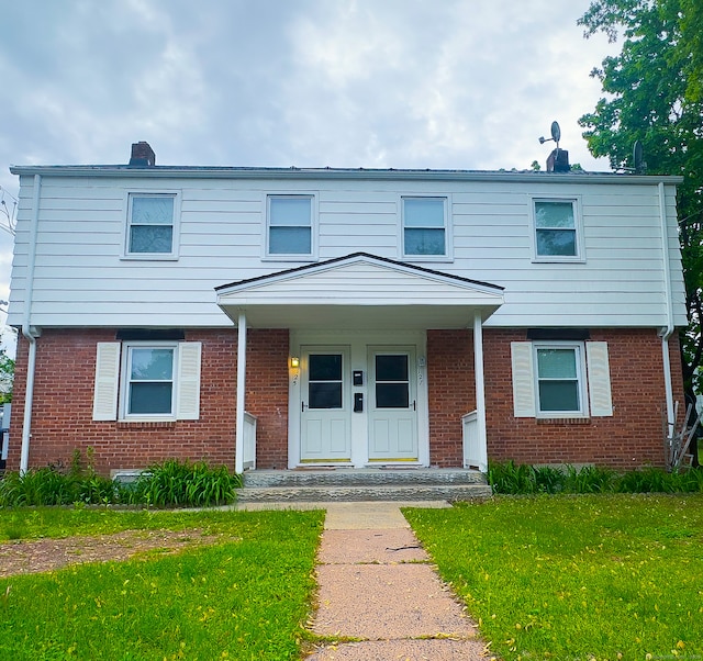 125 Lebanon St, Hartford, CT 06112 - view of front of house with brick siding, a front lawn, a porch, and a chimney
