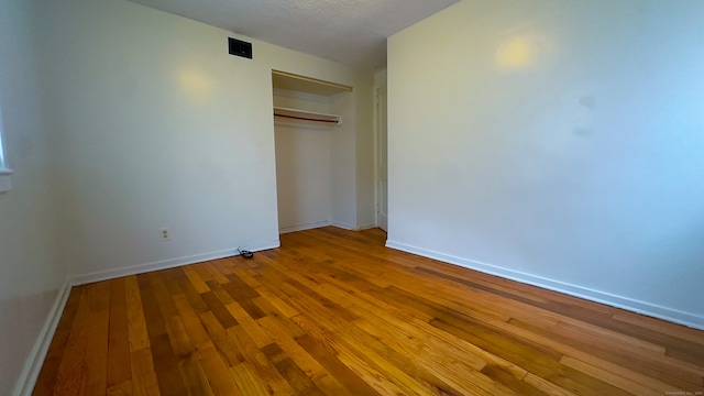 125 Lebanon St, Hartford, CT 06112 - unfurnished bedroom featuring wood-type flooring, baseboards, a closet, and a textured ceiling