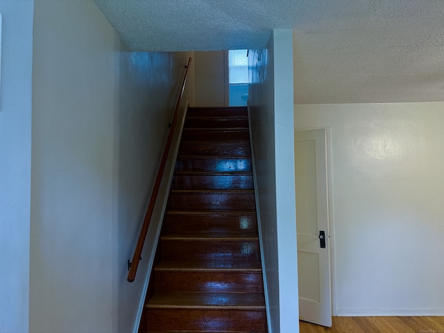 125 Lebanon St, Hartford, CT 06112 - staircase with a textured ceiling, wood finished floors, and baseboards