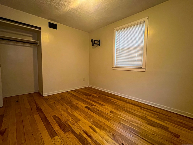 125 Lebanon St, Hartford, CT 06112 - unfurnished bedroom featuring dark wood-style floors, a textured ceiling, a closet, and baseboards