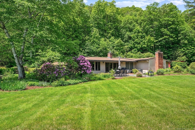 7 Sugar Loaf Cut, Simsbury, CT 06092 - rear view of property with a chimney, a patio, a lawn, and a view of trees