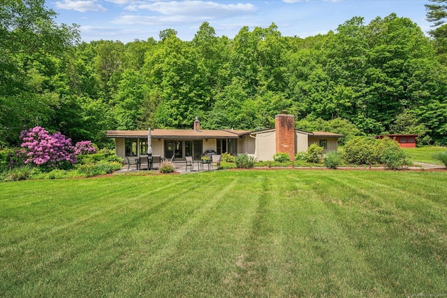 7 Sugar Loaf Cut, Simsbury, CT 06092 - rear view of house with a patio, a chimney, a lawn, and a wooded view