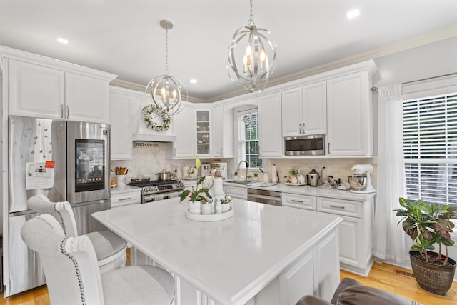 1095 Hope St Unit B, Stamford, CT 06907 - kitchen with a chandelier, stainless steel appliances, white cabinets, light countertops, and recessed lighting