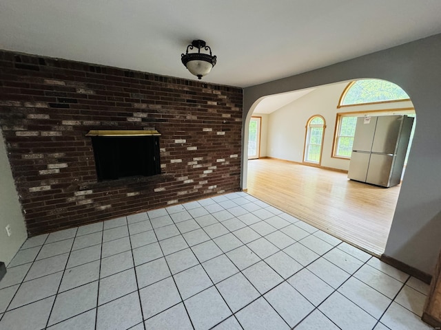 29 Ralph St, Plainfield, CT 06354 - unfurnished living room with arched walkways, brick wall, tile patterned flooring, and baseboards