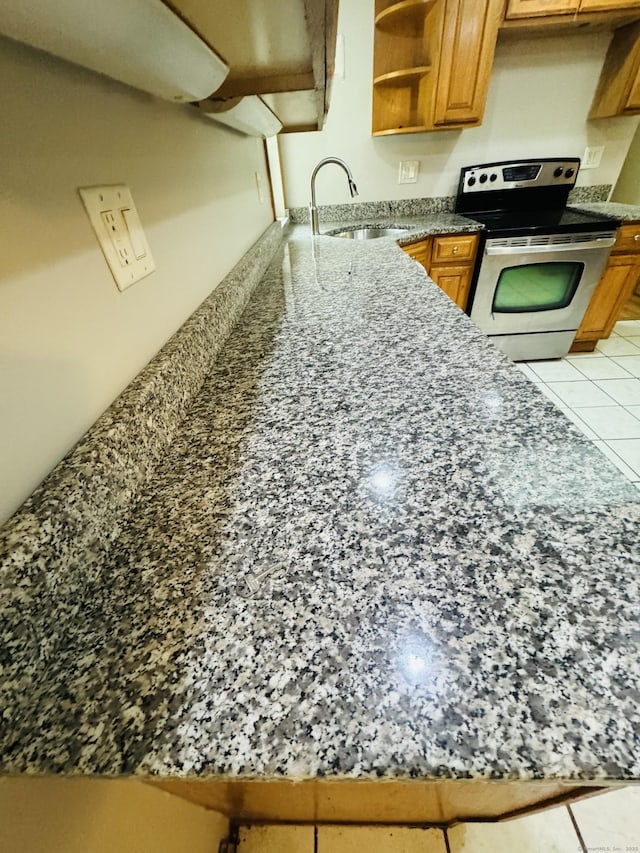 29 Ralph St, Plainfield, CT 06354 - kitchen with stainless steel electric range oven, a sink, brown cabinets, open shelves, and light tile patterned flooring