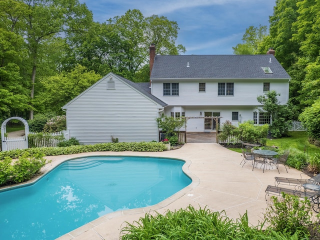 view of pool featuring a deck, a patio, and view of scattered trees