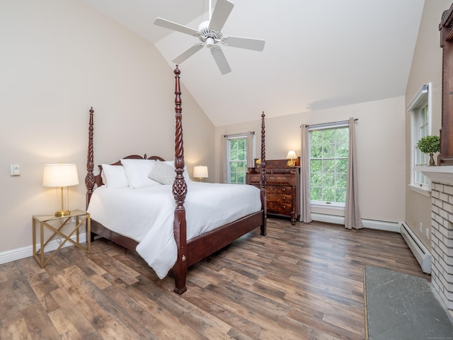 bedroom featuring wood finished floors, lofted ceiling, a fireplace, a baseboard radiator, and a ceiling fan