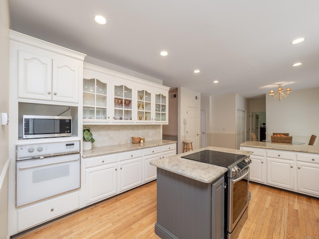 kitchen featuring stainless steel appliances, light wood-style flooring, white cabinetry, and recessed lighting