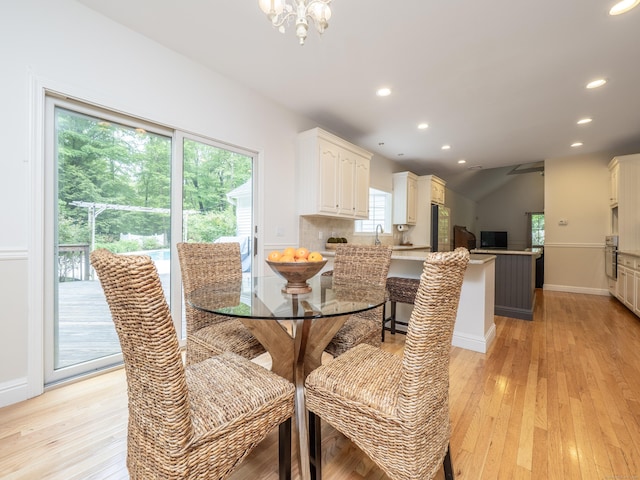 dining space with light wood-style floors, recessed lighting, healthy amount of natural light, a chandelier, and lofted ceiling