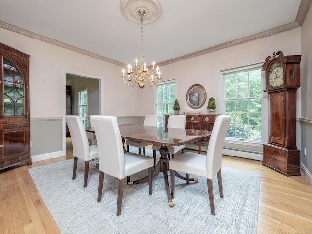 dining space featuring a chandelier, light wood-style flooring, ornamental molding, and baseboards