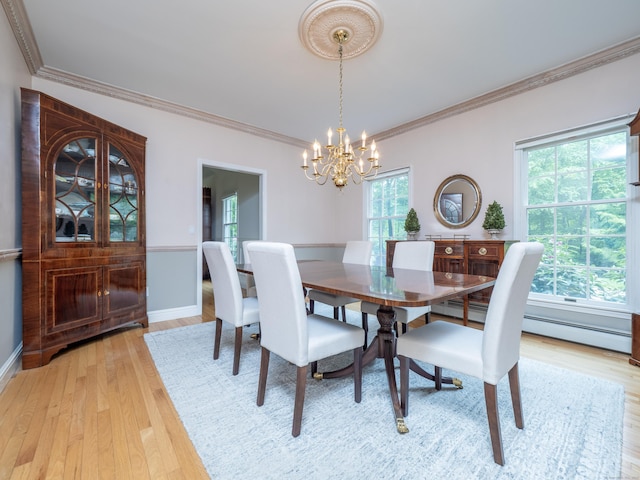 dining space featuring a chandelier, crown molding, light wood-style floors, and baseboards