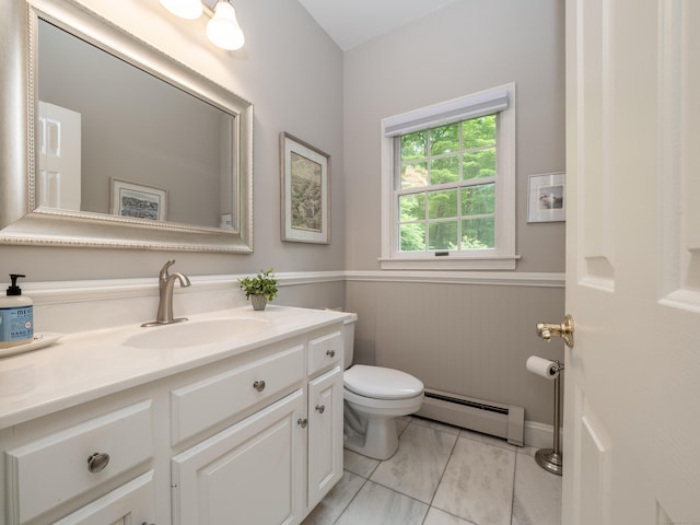 half bath with a baseboard heating unit, toilet, and vanity