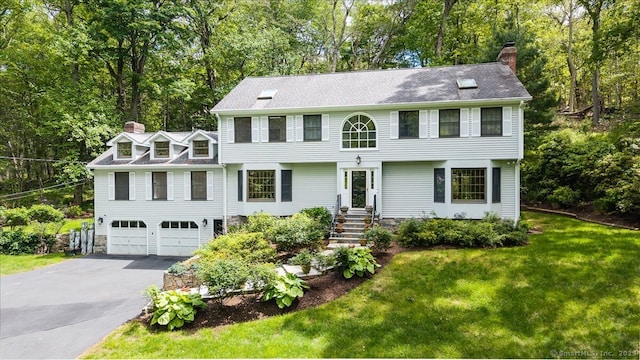 4665 Black Rock Tpke, Fairfield, CT 06824 - colonial home with a chimney, driveway, an attached garage, and view of wooded area