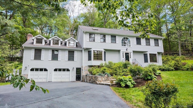4665 Black Rock Tpke, Fairfield, CT 06824 - view of front facade featuring driveway, an attached garage, a chimney, and view of wooded area