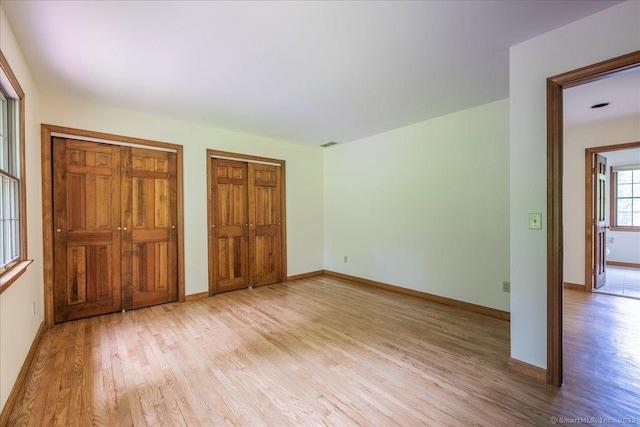 4665 Black Rock Tpke, Fairfield, CT 06824 - unfurnished bedroom featuring two closets, light wood-style flooring, and baseboards
