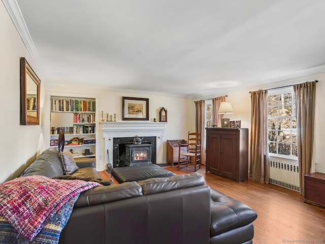 44 Meadow Ridge Dr, Easton, CT 06612 - living room featuring radiator heating unit, ornamental molding, wood finished floors, a warm lit fireplace, and built in shelves