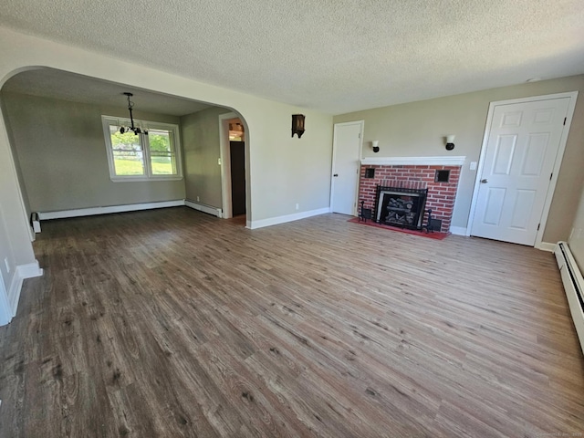 354 Clinton St, New Britain, CT 06053 - unfurnished living room featuring arched walkways, a textured ceiling, dark wood-type flooring, a baseboard heating unit, and a fireplace