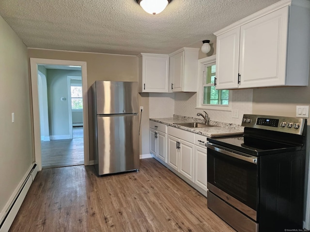354 Clinton St, New Britain, CT 06053 - kitchen with appliances with stainless steel finishes, baseboard heating, light wood-type flooring, white cabinetry, and a textured ceiling