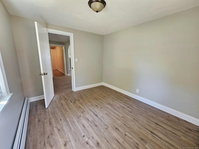 354 Clinton St, New Britain, CT 06053 - unfurnished room with a baseboard heating unit, light wood finished floors, and baseboards