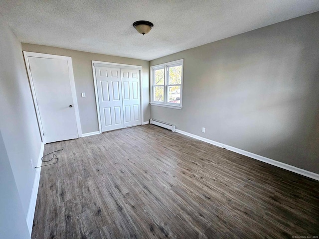 354 Clinton St, New Britain, CT 06053 - unfurnished bedroom featuring a baseboard heating unit, wood finished floors, baseboards, and a textured ceiling