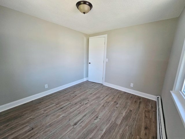 354 Clinton St, New Britain, CT 06053 - unfurnished room with wood finished floors, a baseboard heating unit, baseboards, and a textured ceiling
