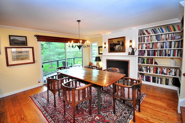 21 Bexley Ct, Goshen, CT 06756 - dining space with a chandelier, hardwood / wood-style flooring, a fireplace, crown molding, and baseboards
