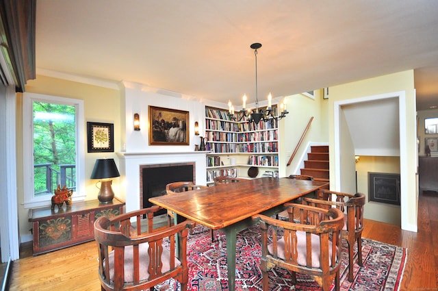 21 Bexley Ct, Goshen, CT 06756 - dining space with a fireplace, a chandelier, and wood finished floors