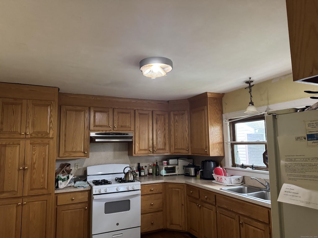 31 E Broad St, Plainville, CT 06062 - kitchen featuring white appliances, under cabinet range hood, and brown cabinetry