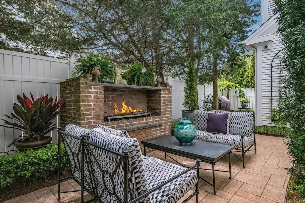 3 Evarts Ln Unit 3, Madison, CT 06443 - fenced backyard with an outdoor brick fireplace and a patio area