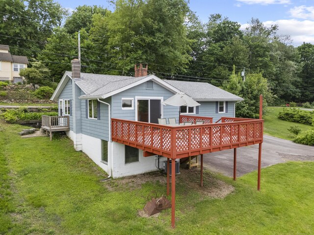 114 Wildwood Rd, East Haddam, CT 06415 - rear view of house featuring a chimney, a wooden deck, a shingled roof, and a lawn