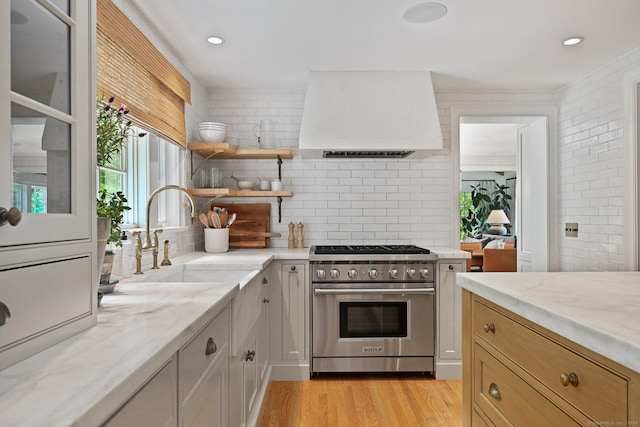 4 Budner Ln, Westport, CT 06880 - kitchen featuring designer range, custom range hood, a sink, decorative backsplash, and light stone counters