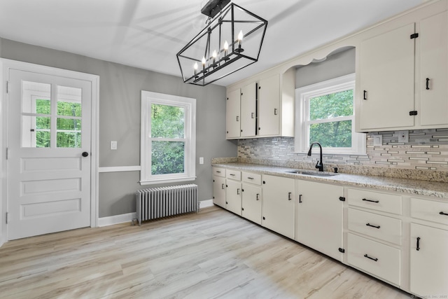291 Maple Hill Rd, Naugatuck, CT 06770 - kitchen with a sink, radiator, tasteful backsplash, and light wood-style floors