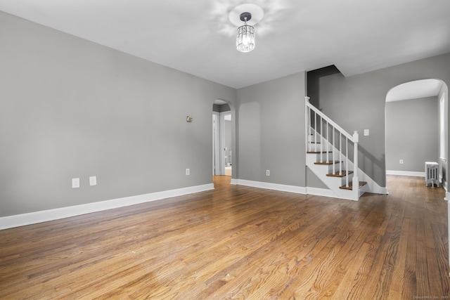 291 Maple Hill Rd, Naugatuck, CT 06770 - unfurnished room featuring arched walkways, wood finished floors, stairs, and baseboards