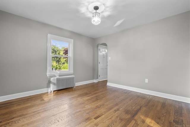 291 Maple Hill Rd, Naugatuck, CT 06770 - unfurnished room featuring radiator heating unit, arched walkways, wood finished floors, and baseboards
