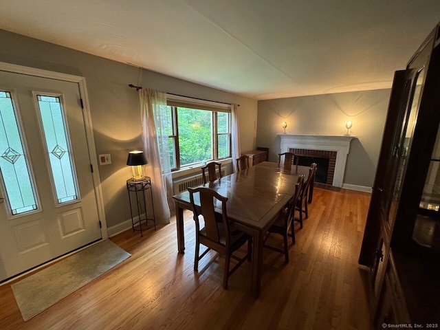 48 Bailey St, Trumbull, CT 06611 - dining space with wood finished floors, a brick fireplace, baseboards, and radiator heating unit