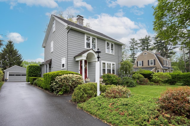 8 Usher Ave, Plainville, CT 06062 - view of front of property with a detached garage, an outbuilding, a chimney, and a front lawn