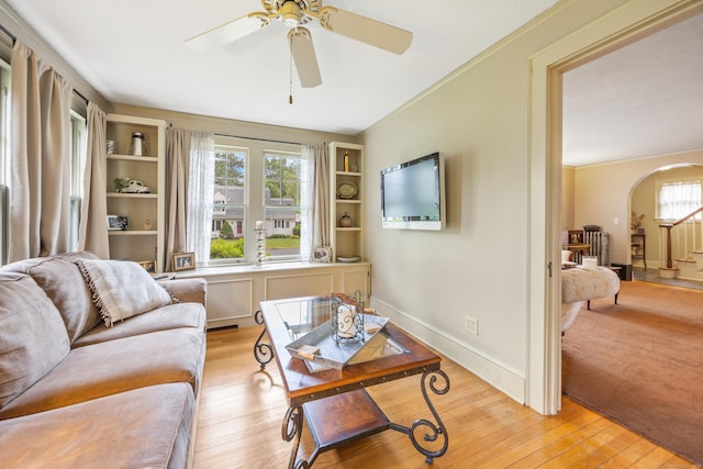 8 Usher Ave, Plainville, CT 06062 - living area featuring arched walkways, light wood-style floors, a ceiling fan, and baseboards