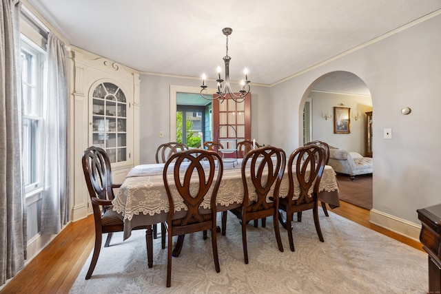 8 Usher Ave, Plainville, CT 06062 - dining space with a chandelier, light wood-style floors, ornamental molding, arched walkways, and baseboards