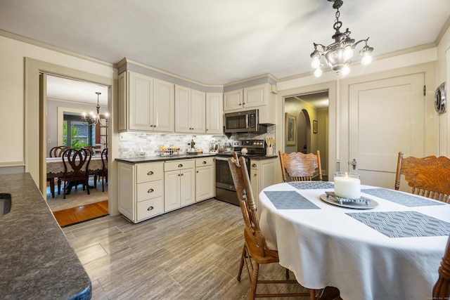 8 Usher Ave, Plainville, CT 06062 - kitchen featuring appliances with stainless steel finishes, a chandelier, decorative backsplash, pendant lighting, and light wood-type flooring