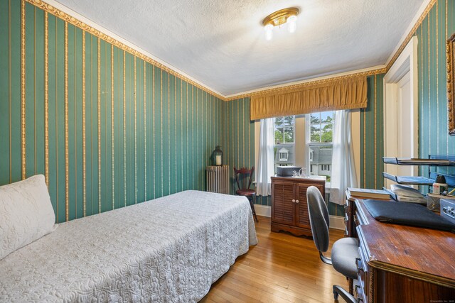 8 Usher Ave, Plainville, CT 06062 - bedroom with light wood-type flooring, crown molding, a textured ceiling, wallpapered walls, and a desk