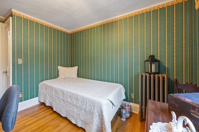 8 Usher Ave, Plainville, CT 06062 - bedroom featuring hardwood / wood-style floors, radiator, baseboards, a textured ceiling, and wallpapered walls