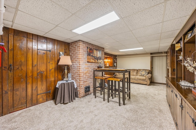 8 Usher Ave, Plainville, CT 06062 - carpeted dining space with a drop ceiling, wood walls, and a dry bar