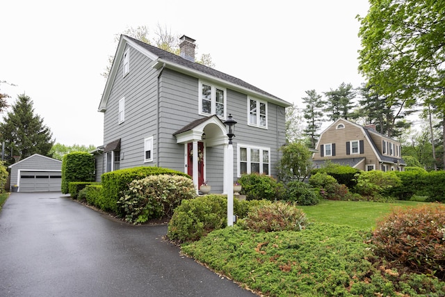 8 Usher Ave, Plainville, CT 06062 - view of front of house with a garage, an outbuilding, a chimney, and a front yard