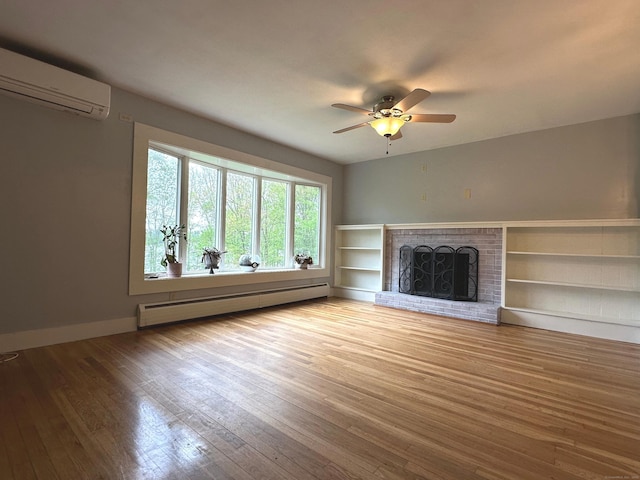 331 Pond Hill Rd, Plainfield, CT 06354 - unfurnished living room with a baseboard heating unit, a wall mounted AC, wood-type flooring, a ceiling fan, and a brick fireplace