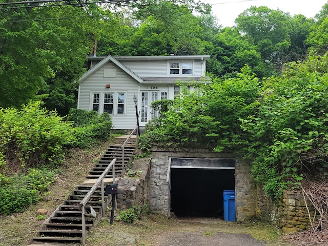 706 Waterville St, Waterbury, CT 06710 - view of front of house with stairs, driveway, stone siding, and a garage