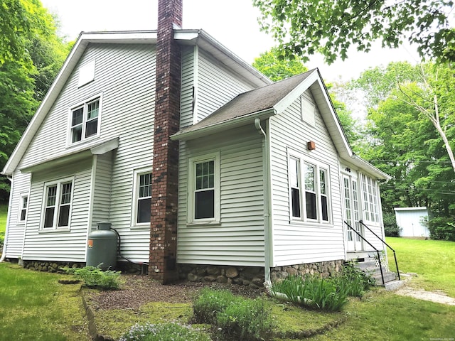 706 Waterville St, Waterbury, CT 06710 - view of property exterior featuring entry steps, a chimney, and a lawn