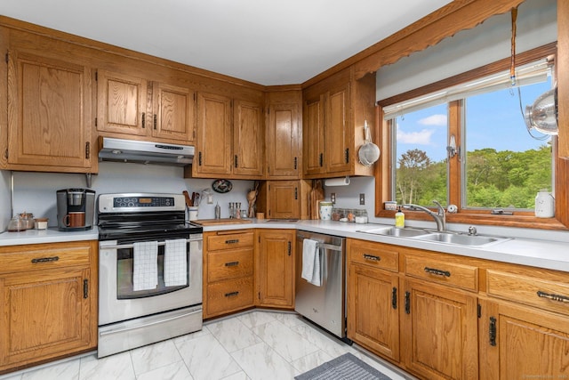 232 Bailey Hill Rd, Killingly, CT 06239 - kitchen with under cabinet range hood, stainless steel appliances, a sink, light marble finish floors, and brown cabinetry