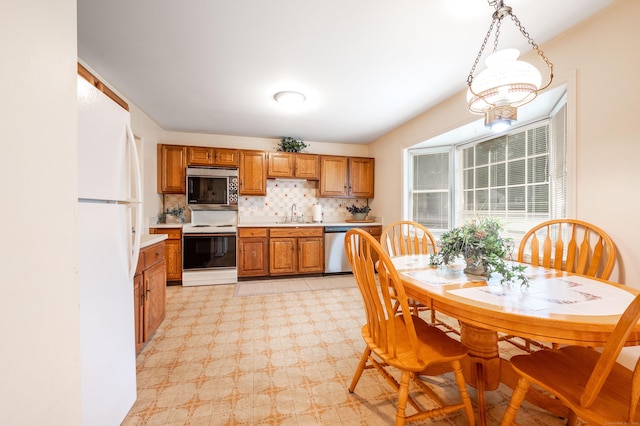 5 Bridgewater Cmn Unit 5, Bridgewater, CT 06752 - kitchen featuring stainless steel appliances, brown cabinets, light countertops, decorative backsplash, and a sink