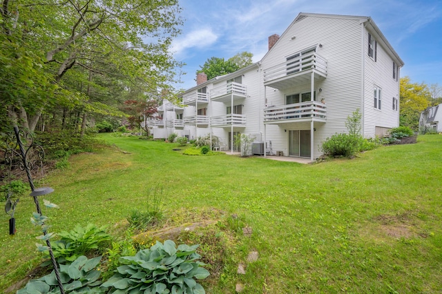 5 Bridgewater Cmn Unit 5, Bridgewater, CT 06752 - back of house with a chimney, a balcony, a lawn, and central AC