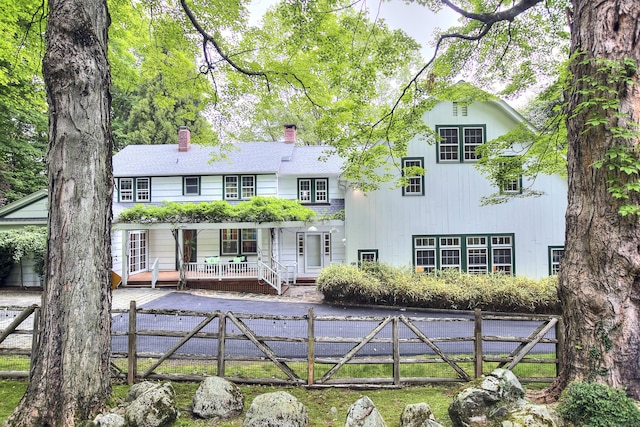 481 Ridgefield Rd, Wilton, CT 06897 - rear view of property with a fenced front yard, a chimney, and a porch